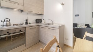 A compact kitchen with a built-in stove, microwave, and sink.