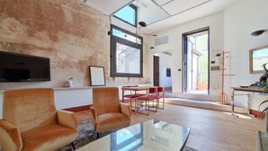 A modern living room with two sofas, a glass coffee table, and a large window providing natural light. - CS Stylish Loft with Terrace (Roma)