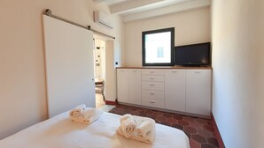 A hotel room with a bed, a TV, a wardrobe, and a window. - CS Stylish Loft with Terrace (Roma)