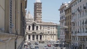 A historic building with a prominent clock tower and dome, surrounded by a busy street with cars and pedestrians. - CS Central Station Termini / Monti Apartment (Roma)