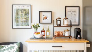 A kitchen counter with a coffee machine, a framed Monet painting, and a framed coffee machine instruction manual.