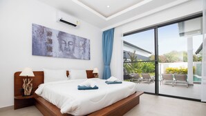 A modern bedroom with a large bed, a ceiling fan, and a view of the outdoor area. - Villa Malaki, pool villa 2 bedrooms at rawai (Tambon Rawai)
