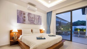 A modern hotel room with a large bed, two bedside lamps, a wall-mounted air conditioner, and a view of the outdoor patio. - Villa Malaki, pool villa 2 bedrooms at rawai (Tambon Rawai)
