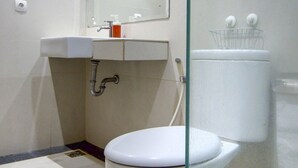 Een moderne badkamer met toilet, wastafel en spiegel.