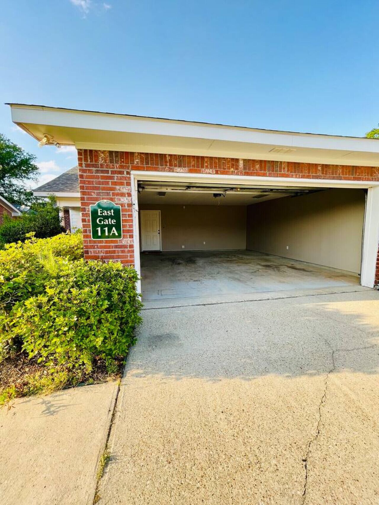 Eine Garage mit Ziegelwand und einem grünen Schild, das 'East Gate 11A' anzeigt.