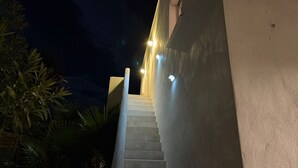 A nighttime view of a staircase leading up to a building with illuminated steps and walls. - Ideal stay, with beaches, ponds and tramway just around the corner! Apt 2 (Pérols)