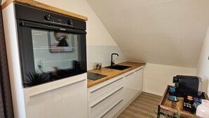 A compact kitchen with a built-in oven, a sink, and a wooden countertop. - Elodia Luxury Apartment - Wi-Fi, Smart TV, Terrace, Kitchen, Towels (Heidenheim an der Brenz)
