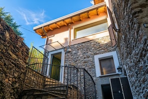 A stone building with a wooden staircase leading to a second-floor entrance. - Cremia Dreamhouse (Cremia)