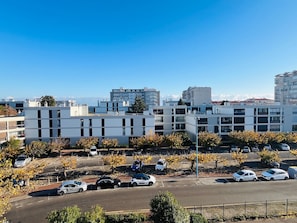 Un quartier urbain moderne, avec des bâtiments contemporains, un parking et un ciel d’un bleu éclatant.