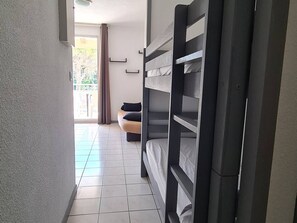 A room with bunk beds, a sofa, and a view of the outdoors. - Studio with Terrace and Parking in Canet-en-Roussillon (Canet-en-Roussillon)