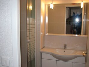 Ein Badezimmer mit Waschbecken, Spiegel und Lampen.