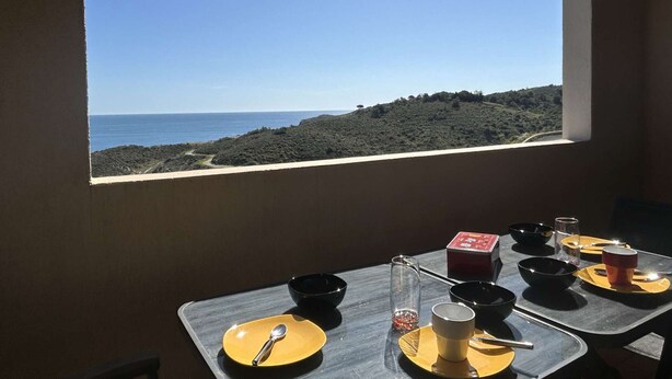 A table set for dining with a view of the sea and hills. - Modern 2-room apartment with parking and Wi-Fi in Banyuls-sur-Mer (Banyuls-sur-Mer)
