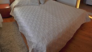 A bedroom with a large bed, a wooden headboard, a bedside table, and a mirror. - Stunning View Suite With Balcony (Trogir)