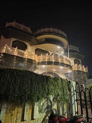 A multi-story building with a series of balconies and a central dome. - Naari Home Stay (Mathura)