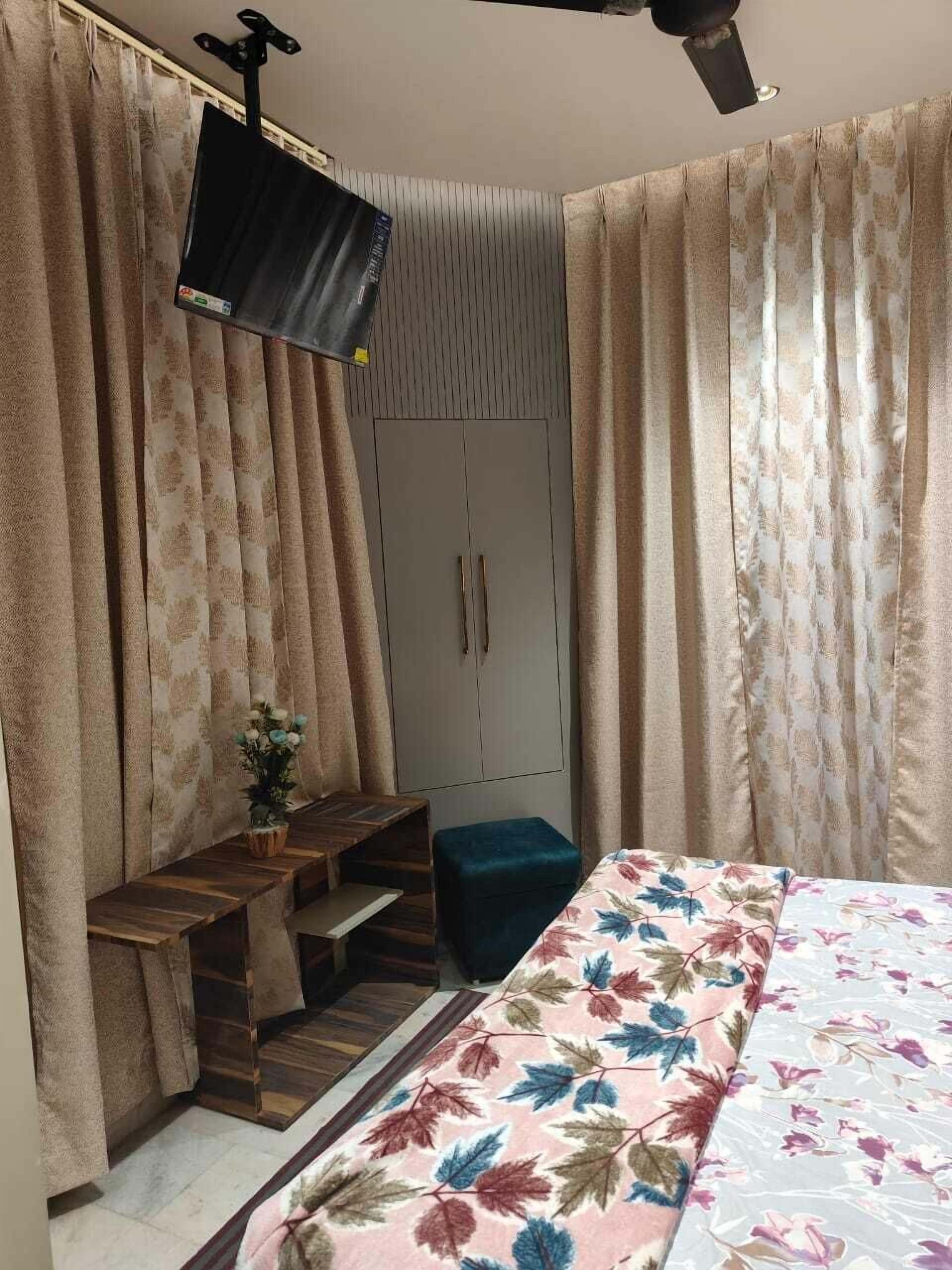 Un dormitorio con cama, escritorio, armario y ventilador de techo.