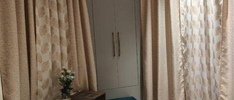 Un dormitorio con cama, escritorio, armario y ventilador de techo.