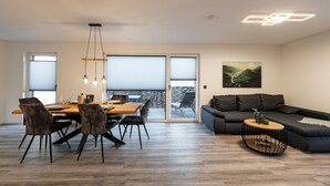 Ein modernes Wohnzimmer mit Essbereich, einer Couch und einem Couchtisch.