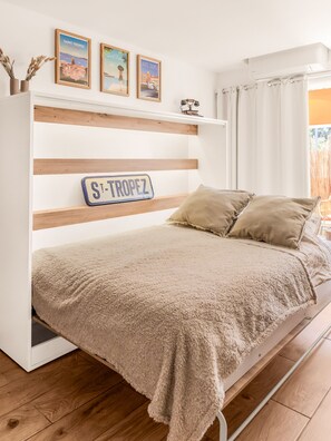 Une chambre à coucher avec un lit, une tête de lit ornée d’une inscription et des décorations murales.