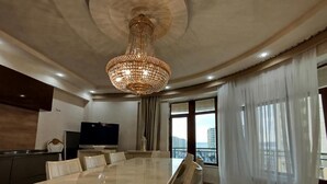 A spacious dining area with a large table and chairs, a chandelier, and a view of the city through large windows. - Baku Lake view 3 bedrooms apartment (Baku)