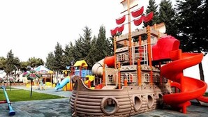 A playground with a pirate ship play structure, slides, and various play equipment. - Baku Lake view 3 bedrooms apartment (Baku)