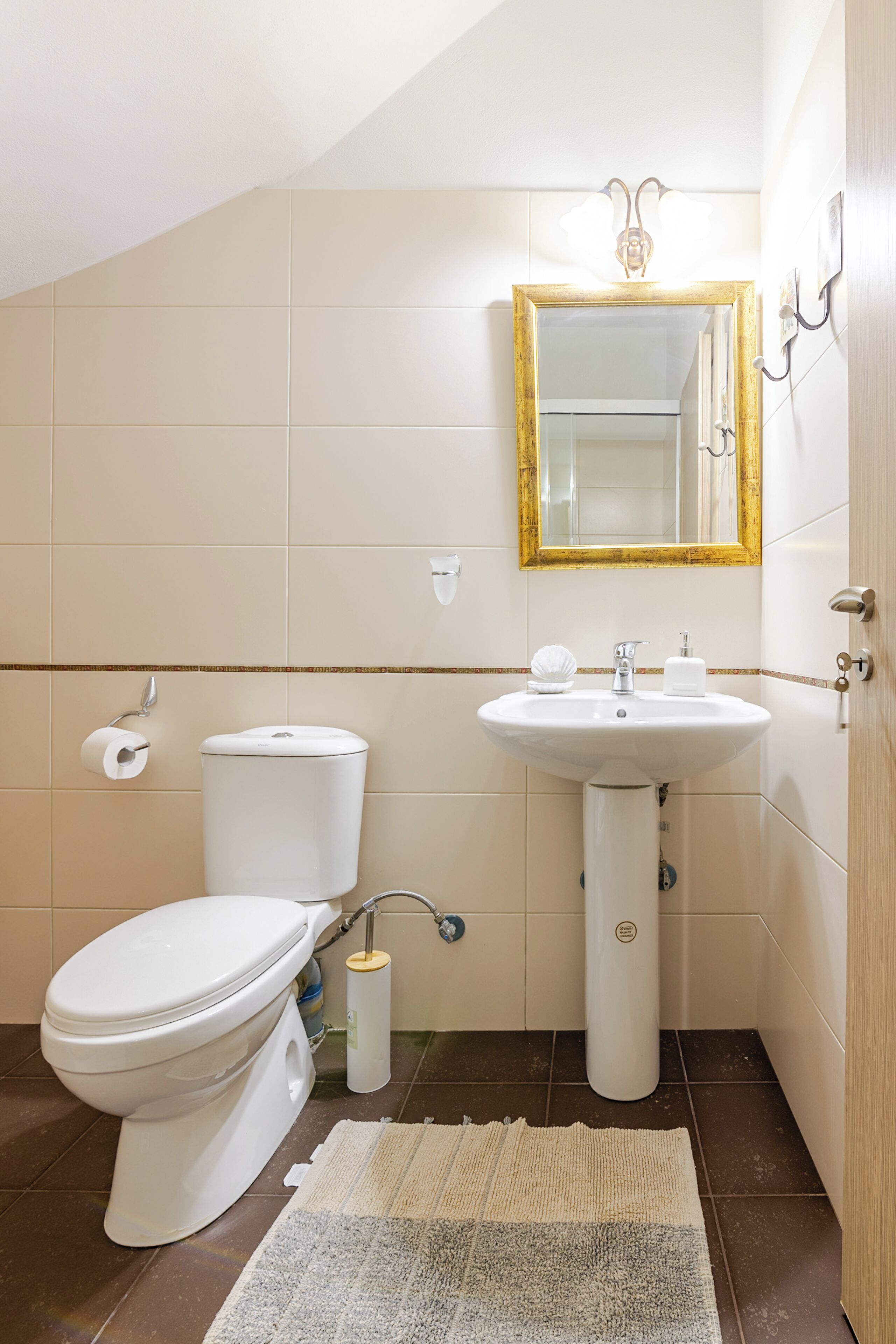 Ein Badezimmer mit Toilette, Waschbecken und Spiegel.