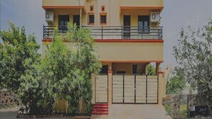 Un immeuble à plusieurs étages doté de balcons et d’une entrée sécurisée par un portail.