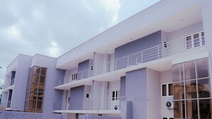 Um edifício moderno de vários andares com varandas e grandes janelas.