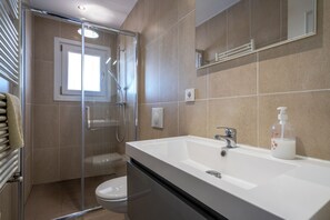 A modern bathroom with a glass-enclosed shower, a white sink with a soap dispenser, and a toilet. - Casa Blanca - Exclusive villa with infinity pool and panoramic views (El Mas Fumats)