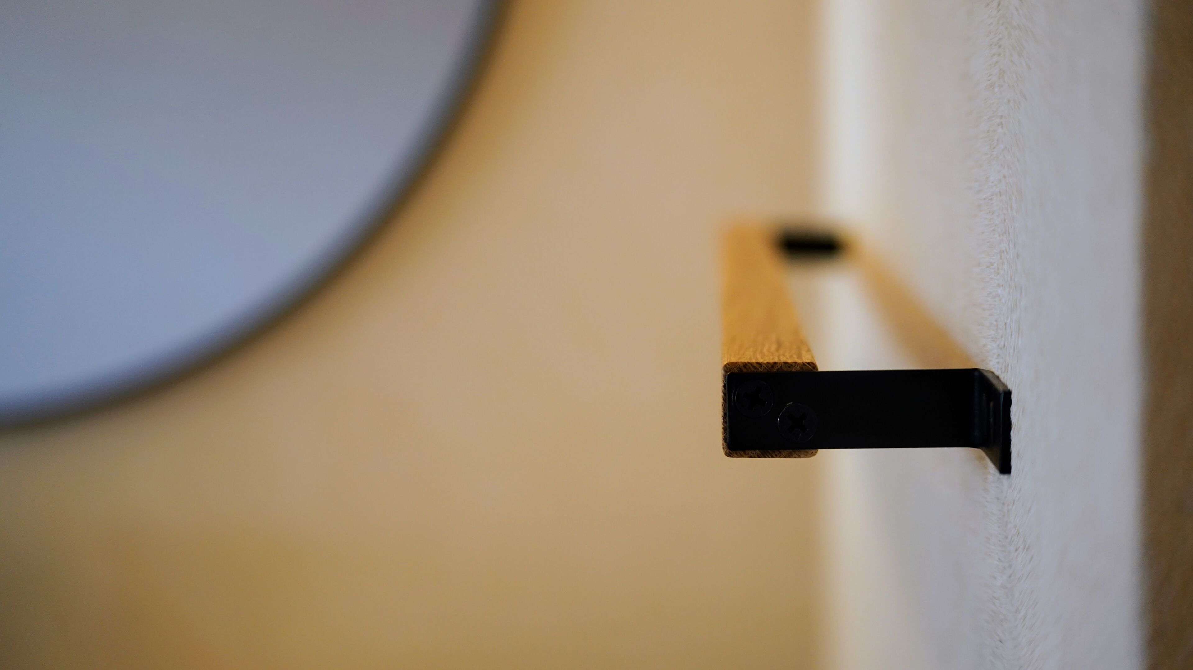 Primer plano de una bisagra de madera fijada a una pared.