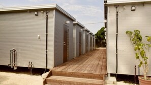 Una fila de casas móviles portátiles con un pasillo de madera que las conecta.
