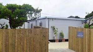 Una entrada portonada a un edificio con un letrero que dice 'MUMBU STAY'.