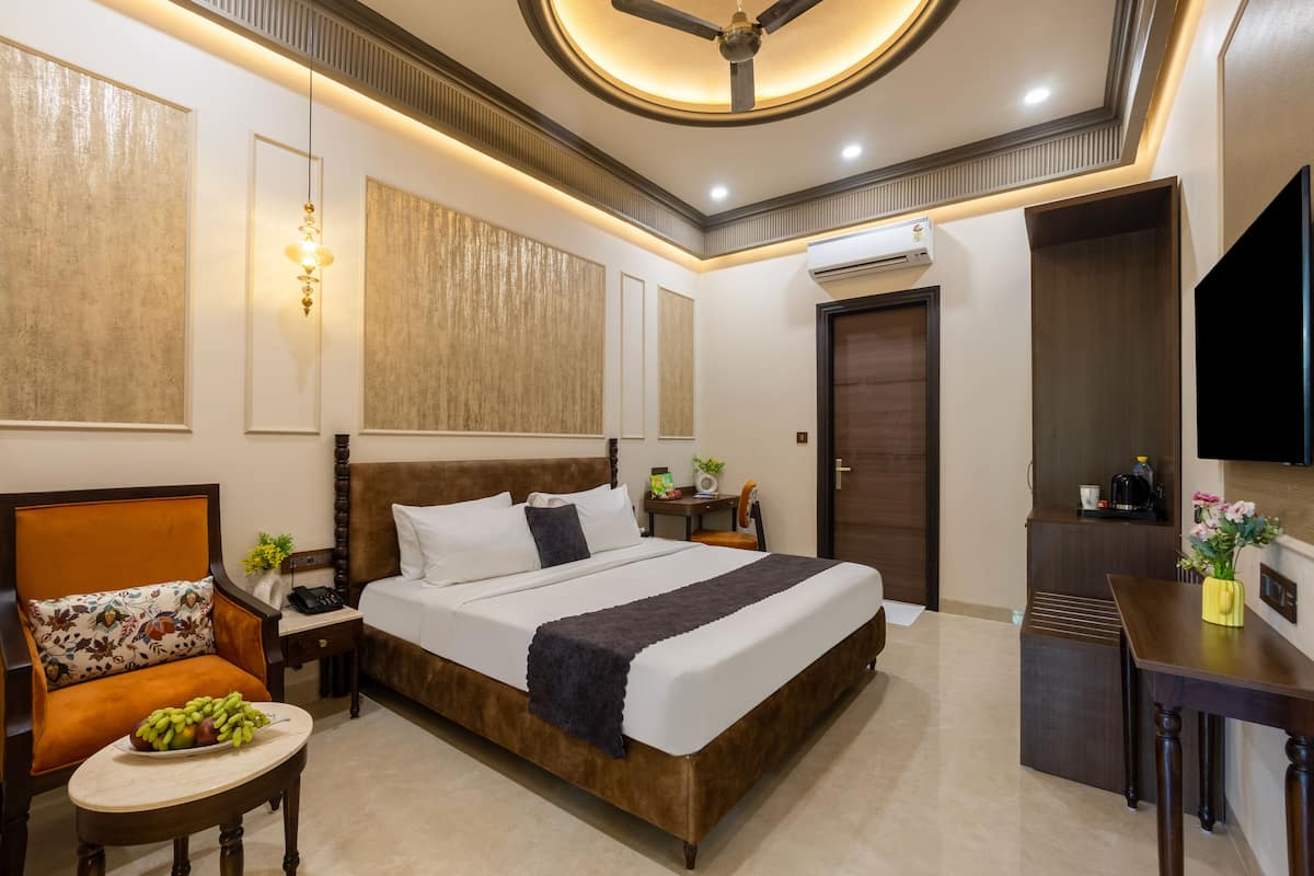 Una habitación de hotel con una cama grande, un escritorio, una silla y una televisión.