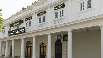 A building with a classic architectural style, featuring a row of columns and arched doorways. The facade includes multiple signs for 'Salt Stayz' and 'Autograph'.