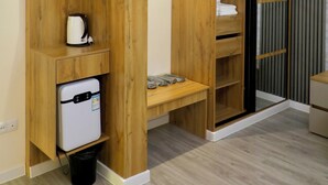 Een moderne kamer met houten kasten, een inbouw mini-koelkast en een kleedkamer met een schuifdeur.