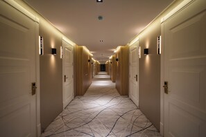 A hotel hallway with doors numbered 4017 to 4018, a patterned carpet, and recessed lighting. - Lakeside Hotel By EDEN Group  (Tashkent)