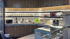 Una cocina moderna con salpicadero de madera, isla de cristal y plantas colgantes.