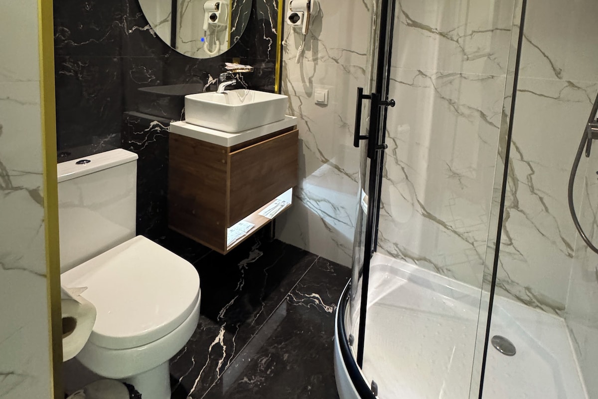 A modern bathroom with a toilet, sink, and shower.