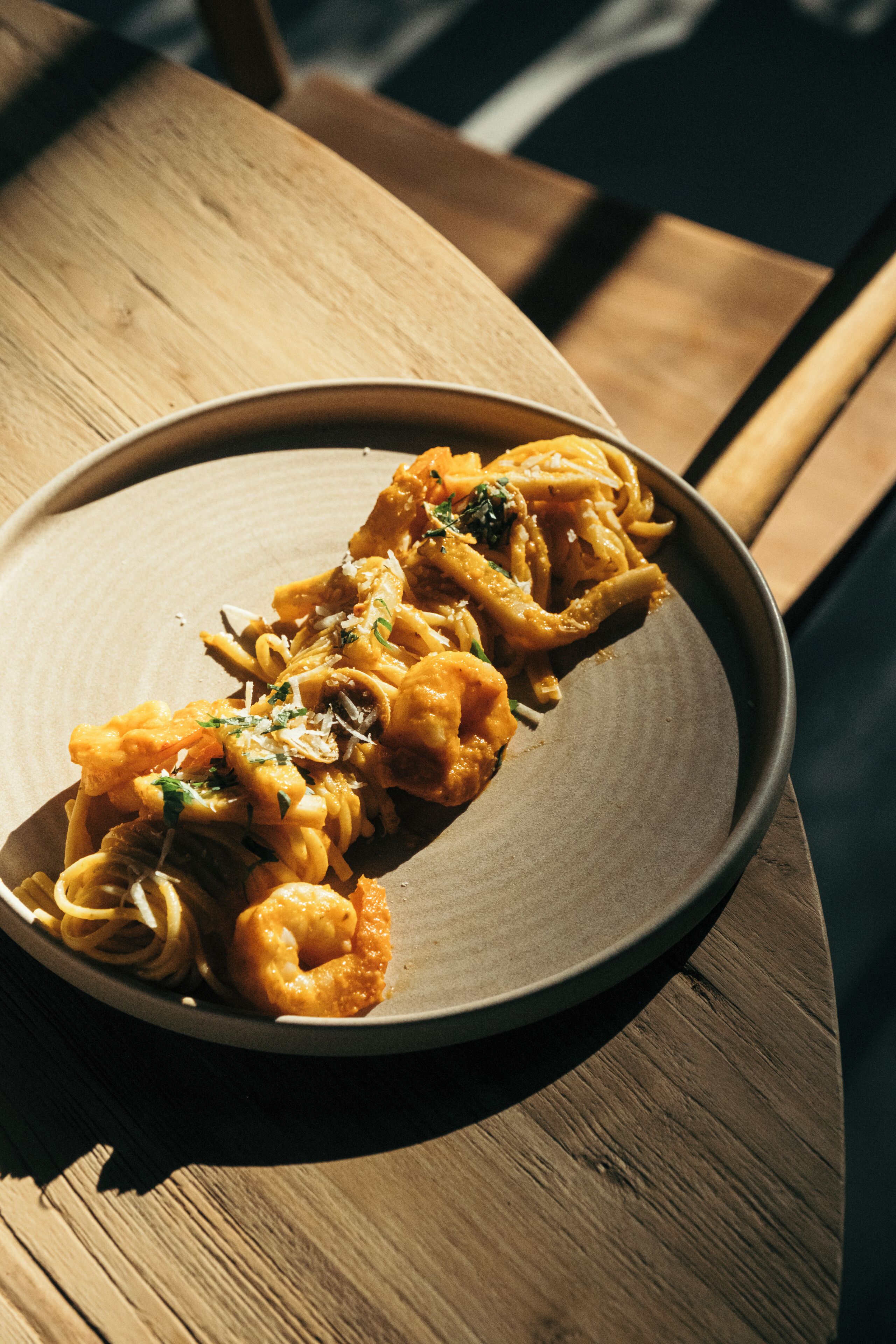 A plate of pasta on a wooden table.
