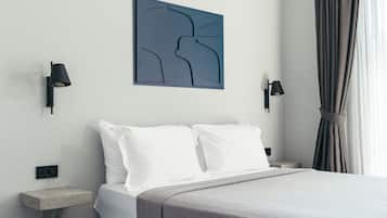 Une chambre à coucher moderne avec un grand lit, une table de chevet, une lampe fixée au mur et un luminaire au plafond.
