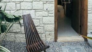 A building with a stone facade, a wooden bench, and a door marked with the number 206.