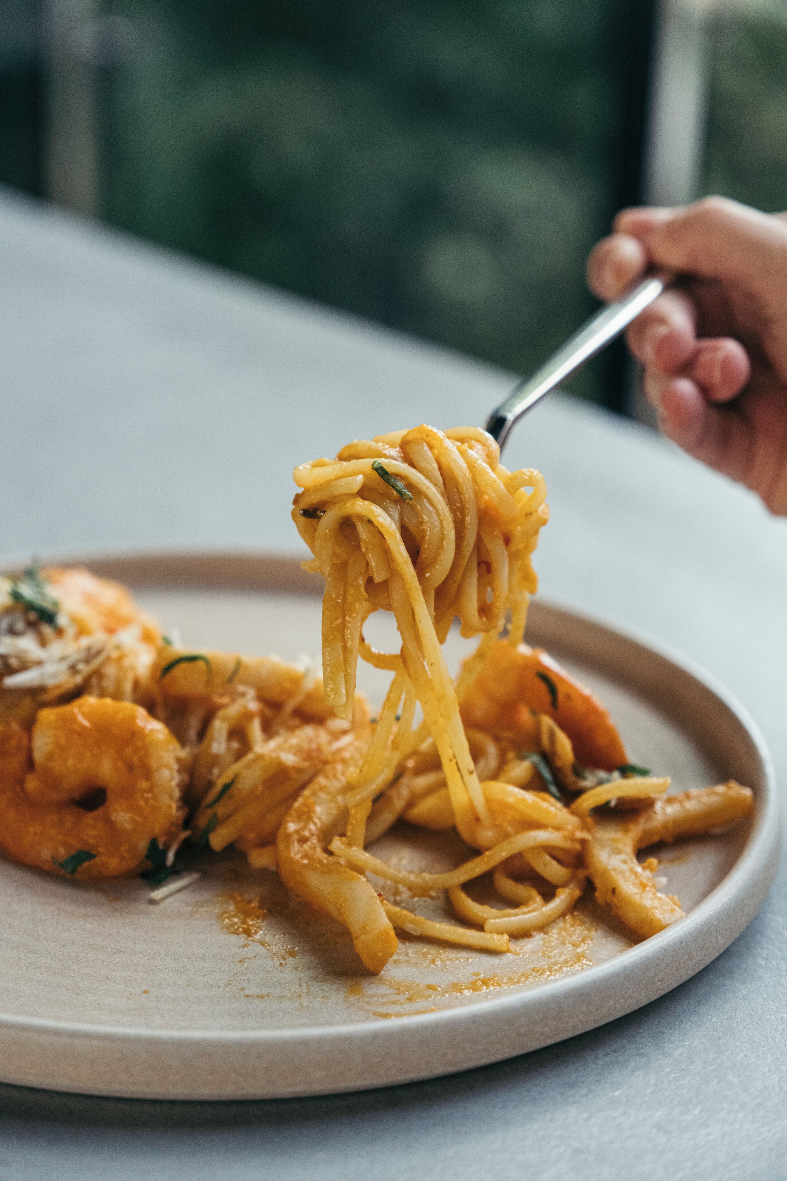 A plate of spaghetti with shrimp and herbs.