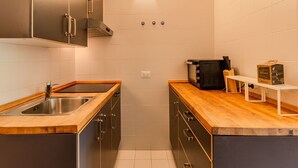 A compact kitchen with a stainless steel sink, wooden countertops, and a built-in oven. - Nice apartment for 4 guests with TV, balcony and panoramic view (Ragoli)