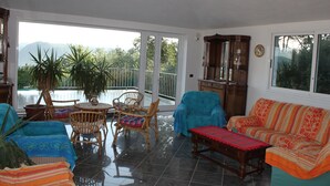 A spacious living area with a balcony, a sofa, a coffee table, and a dining table with chairs. - Villa Bobolino, your Tuscan vacation with private pool (18 people) (Montelupo Fiorentino)