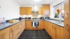 Una cocina moderna con armarios de madera, lavavajillas y microondas.