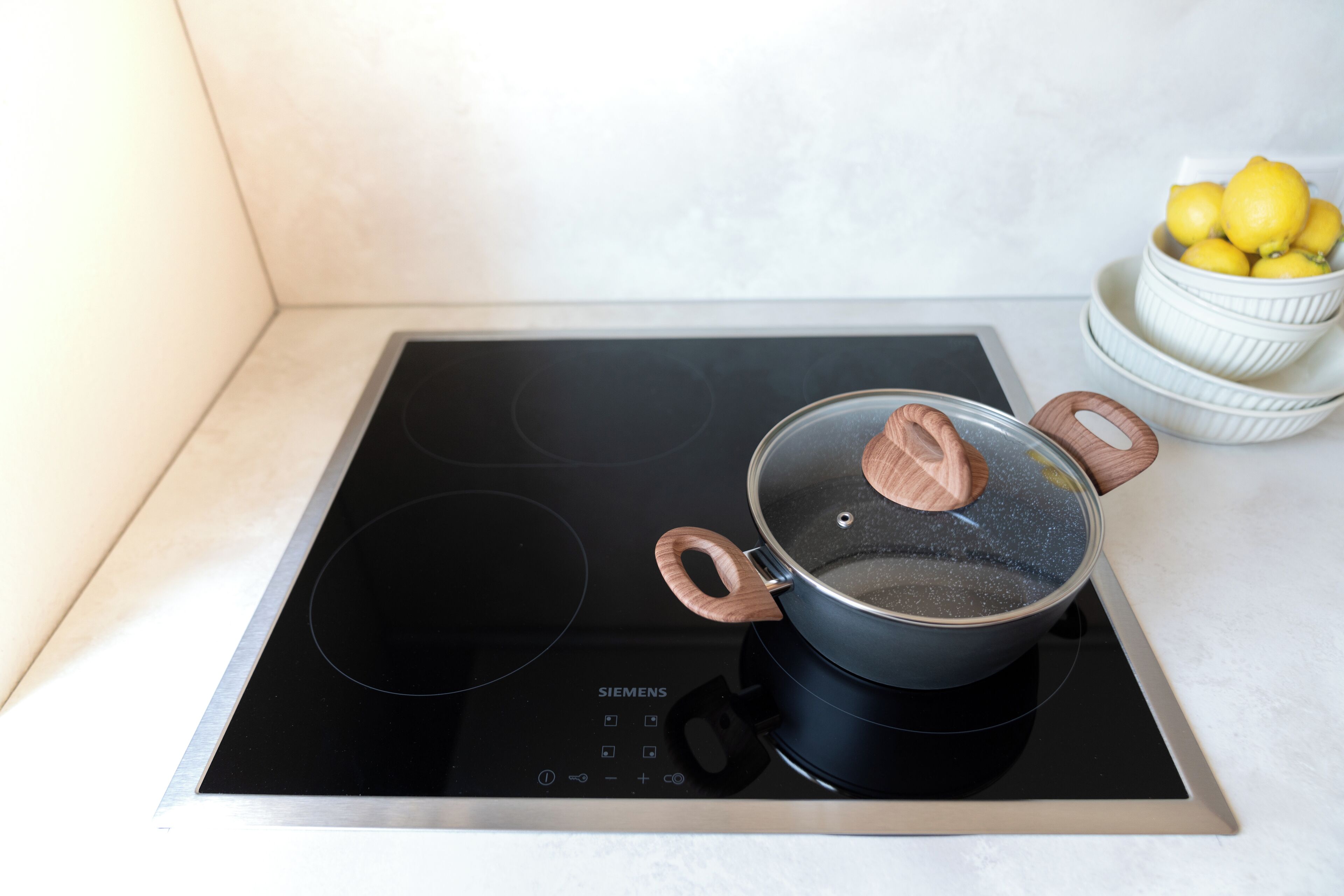 Une plaque de cuisson à induction Siemens avec une casserole dessus.