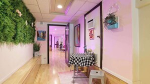 A hallway with a checkered table, a pink rug, and a green wall with plants. - Barbiecore Dream Pad in Sacramento! (Sacramento)