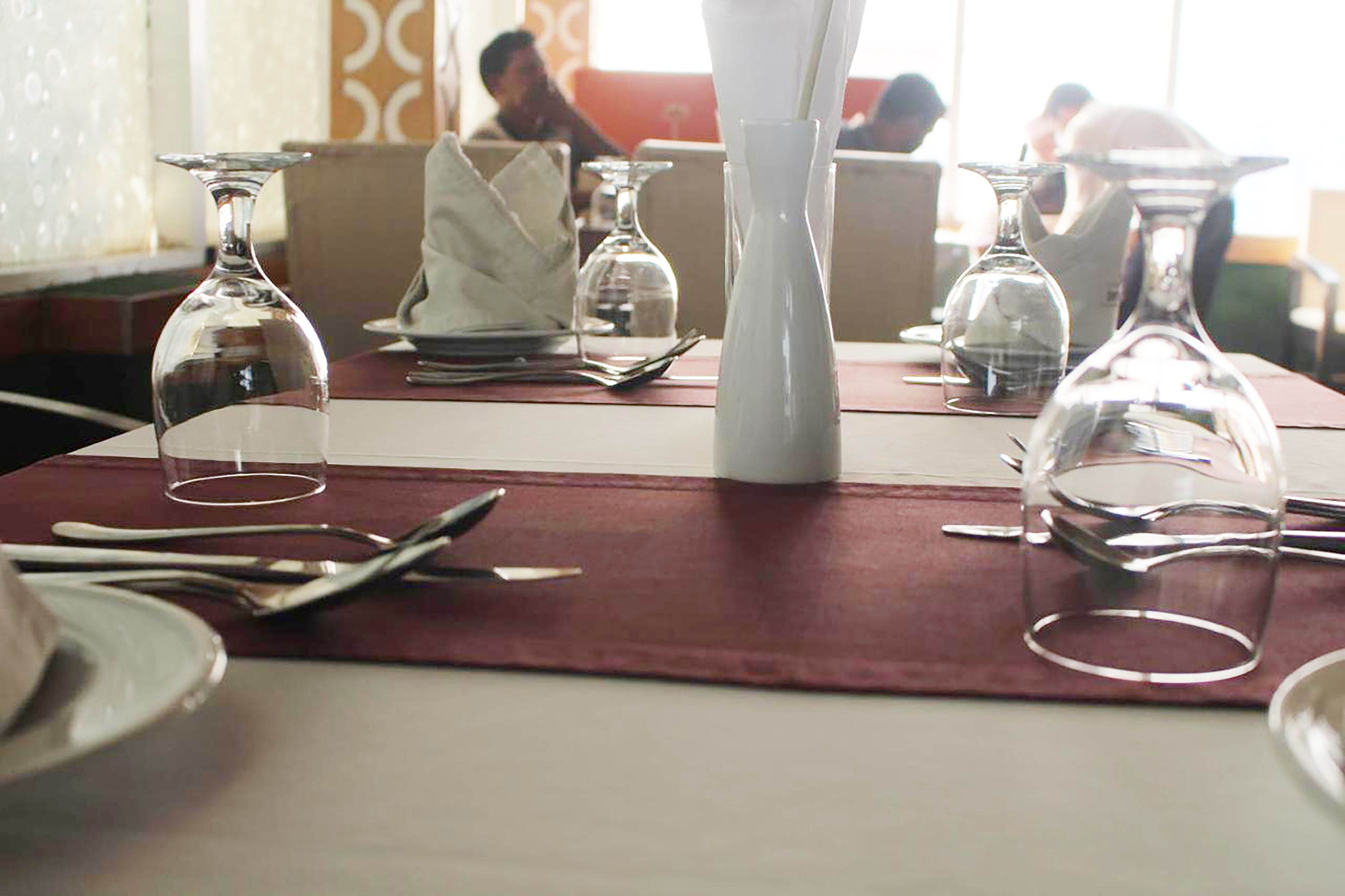 A dining table set with wine glasses, cutlery, and plates, indicating a restaurant setting.
