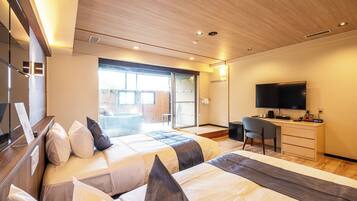 Ein modernes Hotelzimmer mit zwei Betten, einem Schreibtisch, einem Flachbildfernseher und einer Glastür zum Balkon.