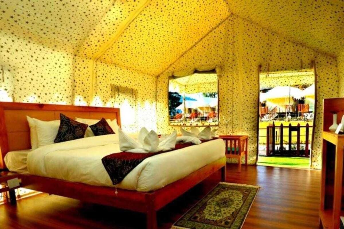 Una camera da letto con un letto di legno, un comodino e vista su uno spazio esterno attraverso una porta.