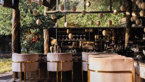 An outdoor bar area with cushioned seating and hanging spherical light fixtures. - Hemingways Eden Residence (Ongata Rongai)
